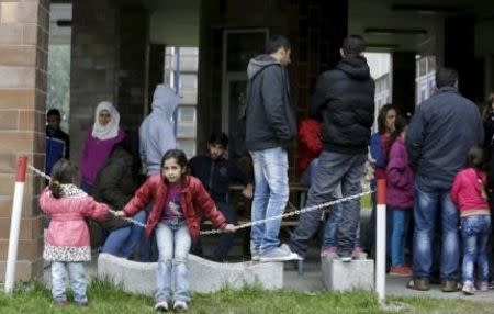 Syrian migrants, who said they were pressured by Austria to leave the country for Slovakia, gather in front of a building acting as a temporary refugee camp in Gabcikovo, Slovakia, October 8, 2015. REUTERS/David W Cerny