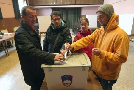 Family members cast ballots at a polling station during referendum on whether to give same-sex couples the right to marry and to adopt children, in Sora, Slovenia December 20, 2015. REUTERS/Srdjan Zivulovic