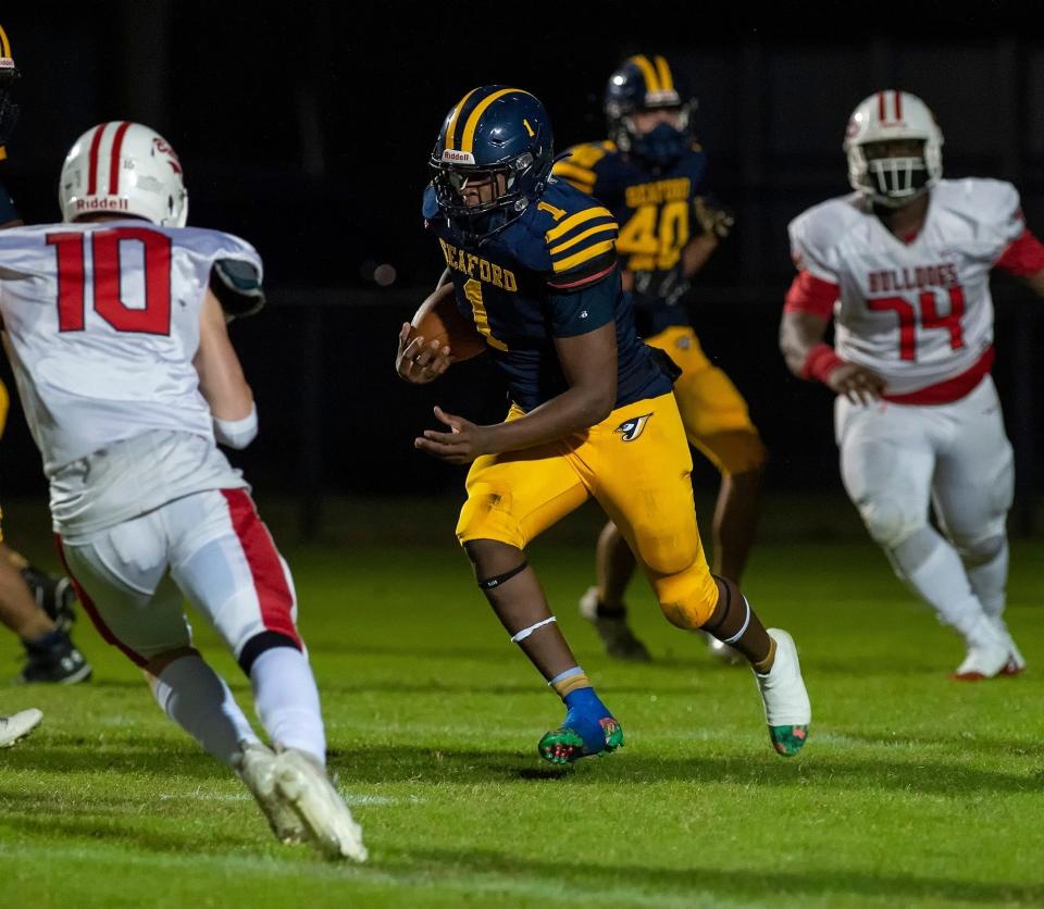 Booker DeShields (1) carries the football for Seaford.