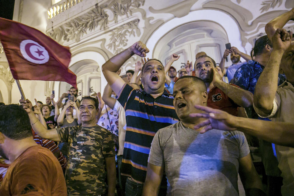 Tunisians celebrate the exit polls indicating a vote in favor of the new Constitution, in Tunis, late Monday, July 25, 2022. Hundreds of supporters of Tunisian President Kais Saied took to the streets to celebrate after the end of voting on a controversial new constitution that critics say could reverse hard-won democratic gains and entrench a presidential power grab. (AP Photo/Riadh Dridi)