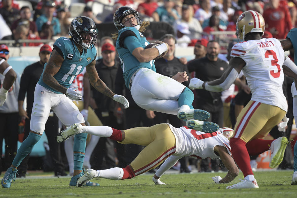 Jacksonville Jaguars quarterback Trevor Lawrence, top center, is upended by San Francisco 49ers cornerback Ambry Thomas, bottom, during the second half of an NFL football game, Sunday, Nov. 21, 2021, in Jacksonville, Fla. (AP Photo/Phelan M. Ebenhack)