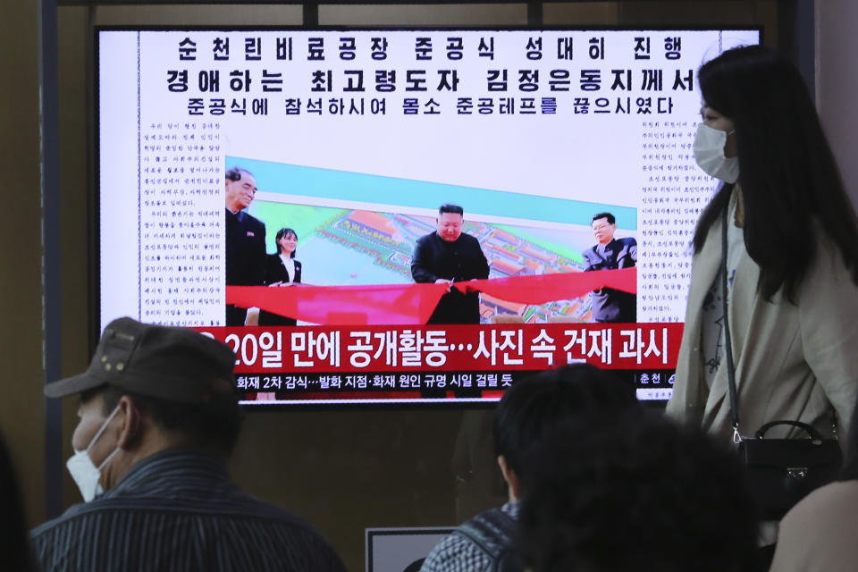 People watch a TV showing an image of North Korean leader Kim Jong Un during a news program at the Seoul Railway Station in Seoul, South Korea, Saturday, May 2, 2020. Kim made his first public appearance in 20 days as he celebrated the completion of a fertilizer factory near Pyongyang, state media said Saturday, ending an absence that had triggered global rumors that he was seriously ill. The sign reads: "Kim Jong Un attended a ceremony marking the completion of a fertilizer factory." (AP Photo/Ahn Young-joon)