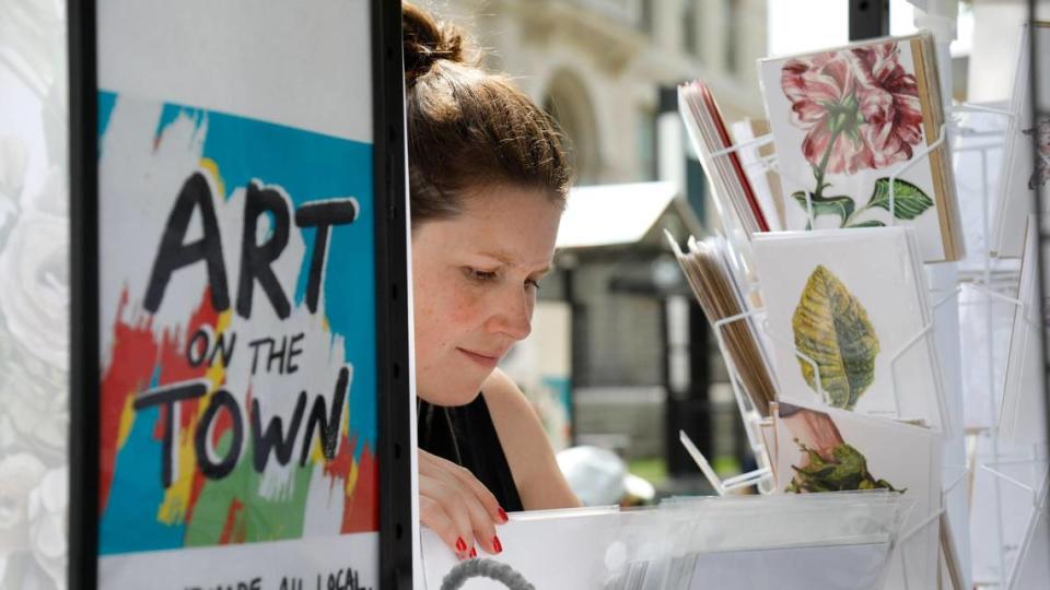 Emily Callahan looks through art prints on Saturday, June 24, 2023 at Fifth Third Pavilion in Lexington, Ky. The Saturday market has space for artists and other vendors.