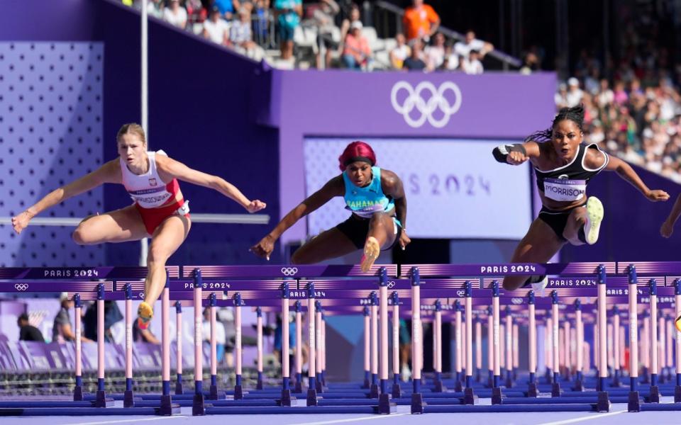 Pia Skrzyszowska, left, of Poland, Denisha Cartwright, of Bahamas and Ebony Morrison, right, of Liberia, compete in the women's 100-meter hurdles heats