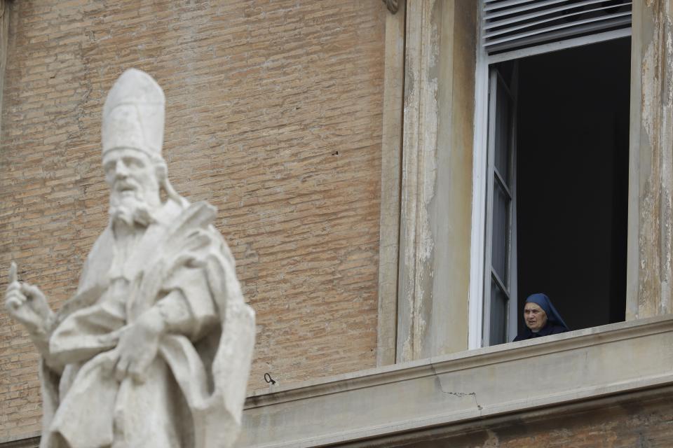 A nun looks from a window overlooking St. Peter's Square as Pope Francis celebrates Easter Mass, at the Vatican, Sunday, April 21, 2019. (AP Photo/Andrew Medichini)