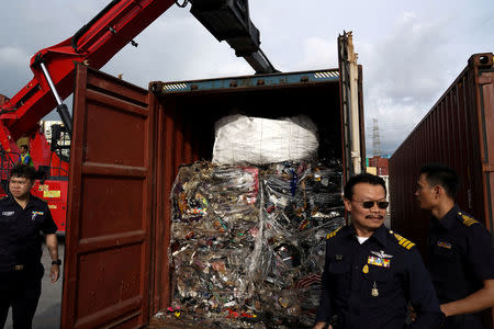 FILE PHOTO: Custom officers stand next to electronic waste hidden in a freight container during a search at Leam Chabang industrial estate, Chonburi province, Thailand, May 29, 2018. REUTERS/Athit Perawongmetha/File Photo