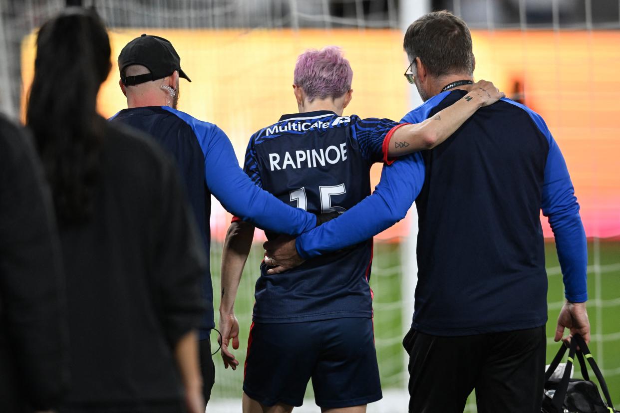 OL Reign's US midfielder #15 Megan Rapinoe is helped off the pitch after an injury in the early minutes of the first half of the National Women's Soccer League final match between OL Reign and Gotham FC at Snapdragon Stadium in San Diego, California, on November 11, 2023. This is Rapinoe's last professional game of her career as she retires from professional soccer. (Photo by Robyn Beck / AFP) (Photo by ROBYN BECK/AFP via Getty Images)