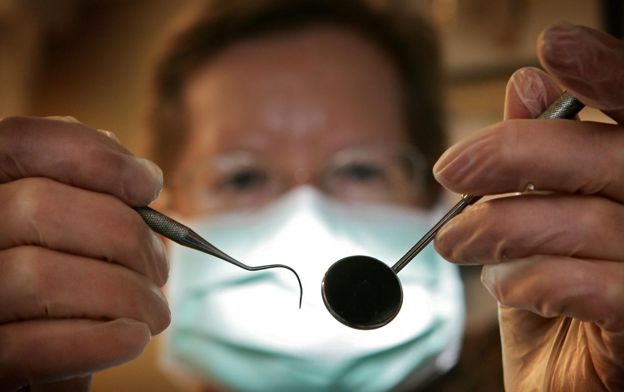 GREAT BOOKHAM, UNITED KINGDOM - APRIL 19:  A patient's eye view, as a dentist poses for the photographer on April 19, 2006 in Great Bookham, England.  (Photo by Peter Macdiarmid/Getty Images)