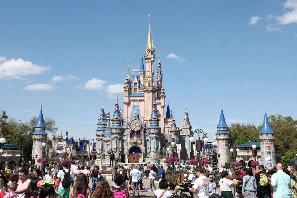 Cinderella Castle at Disney World with visitors in front, clear sky