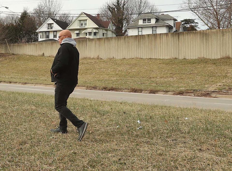 The Rev. Greg Harrison walks to the location along the wall separating the neighborhood from the Innerbelt where his family rented as he was growing up at 636 Douglas Street that was torn down to make way for the Innerbelt.