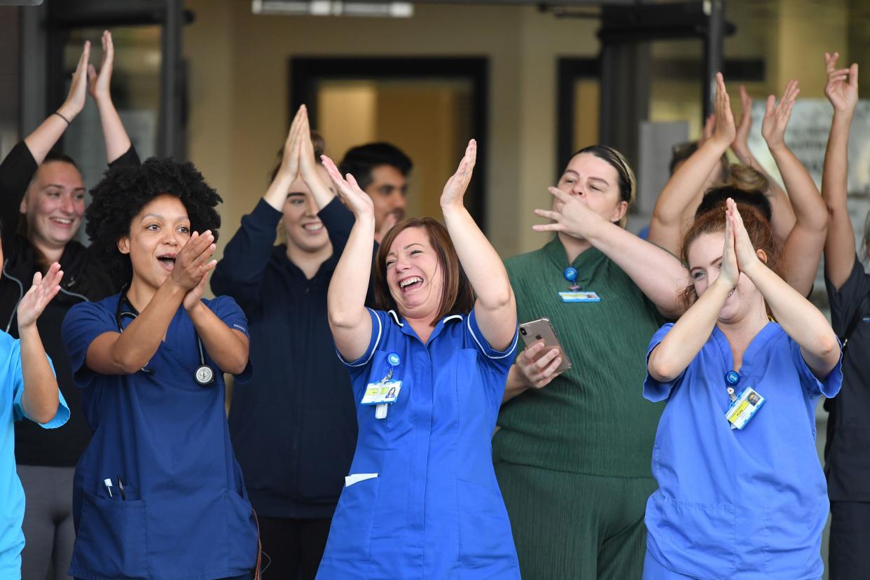 NHS workers participate in a national "clap for carers" to show thanks for the work of Britain's NHS (National Health Service) workers and other frontline medical staff around the country as they battle with the novel coronavirus pandemic, at Aintree University Hospital in Liverpool, northwest England, on May 28, 2020. (Photo by Paul ELLIS / AFP) (Photo by PAUL ELLIS/AFP via Getty Images)