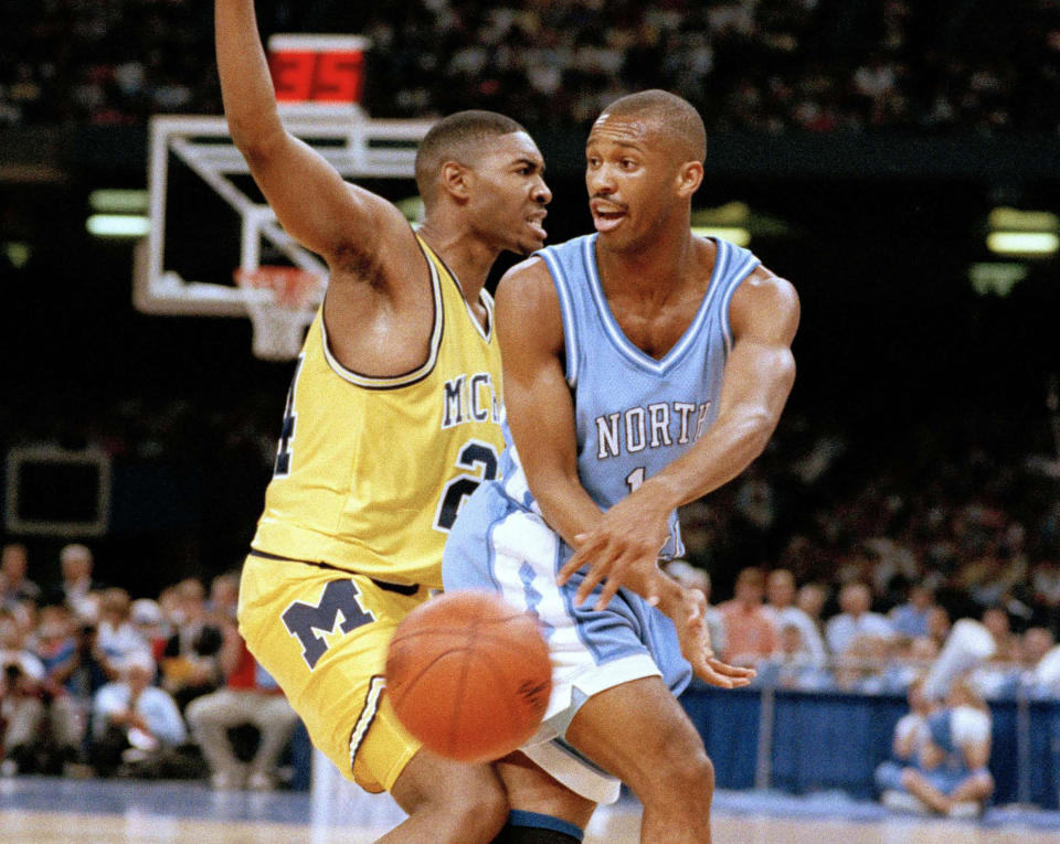 FILE - Michigan's Jimmy King, left, guards against North Carolina's Derrick Phelps, right, during their Final Four NCAA college basketball championship game at the Superdome in New Orleans, April 5, 1993. The game ended a season that had six different No. 1-ranked teams in the AP men’s college basketball poll and 48 different teams appear in the rankings. (AP Photo/Ed Reinke; File)