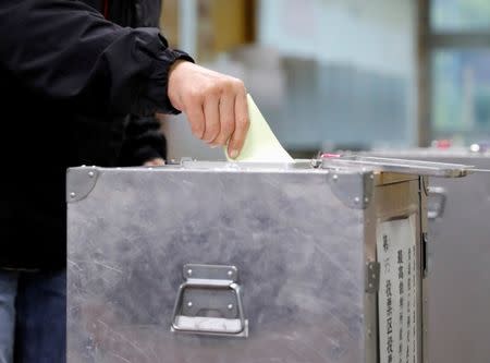 A voter casts his ballot for a national election at a polling station in Tokyo, Japan October 22, 2017. REUTERS/Kim Kyung-Hoon