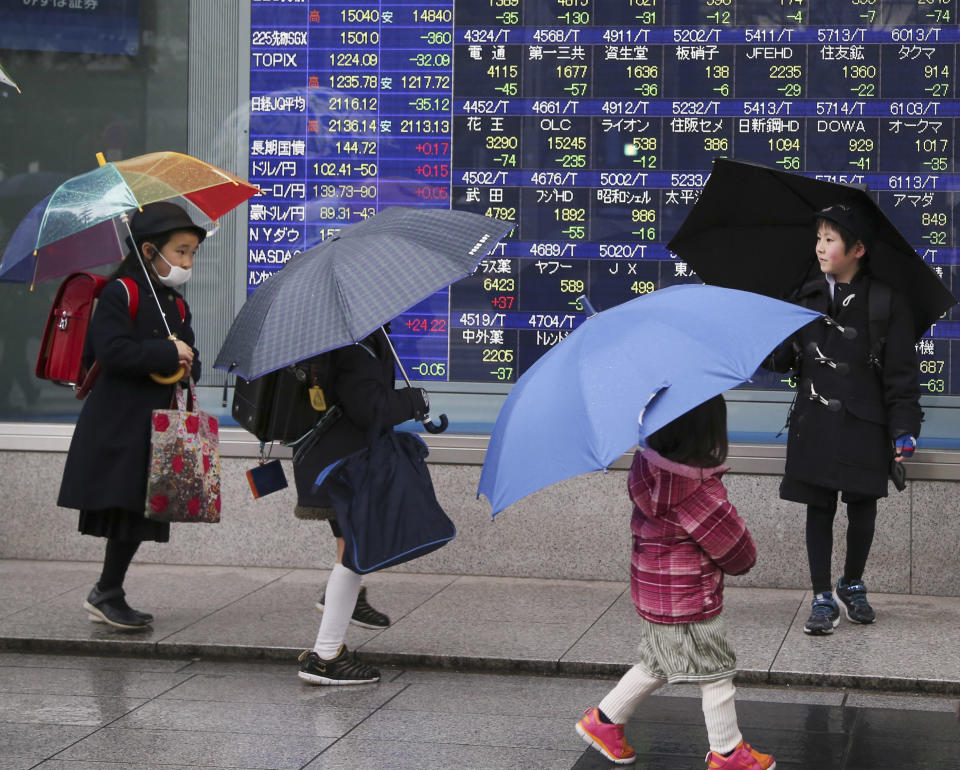 A group of children walk by an electronic stock board of a securities firm in Tokyo Thursday, Jan. 30, 2014. Shares fell Thursday in Asia as weak economic data from China and Japan deepened concerns over ongoing reductions in U.S. monetary stimulus. Japan's Nikkei 225 index was down 2.6 percent at 14,887.96 after the government reported that retail sales fell 1.1 percent in December from the month before. It gained slightly and closed at 15,007.06 for the day. (AP Photo/Koji Sasahara)