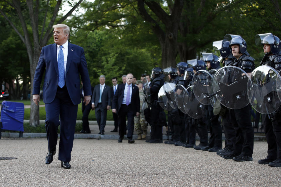 President Donald Trump walks past police in Lafayette Park after he visited outside St. John's Church across from the White House Monday, June 1, 2020, in Washington. Part of the church was set on fire during protests on Sunday night. (AP Photo/Patrick Semansky)