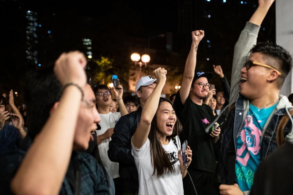 Pro-democracy supporters chant as they celebrate after pro-Beijing candidate Junius Ho lost a seat in the district council elections in Tuen Mun district of Hong Kong, early on November 25, 2019. - Hong Kong's voters turned out in record numbers for local council elections that the city's pro-democracy movement hopes will add pressure on the Beijing-backed government to heed their demands after months of violent protest. Lengthy queues snaked out of polling stations across the territory in the election for 18 district councils, where high turnout is expected to benefit democratic forces. (Photo by Philip FONG / AFP) (Photo by PHILIP FONG/AFP via Getty Images)