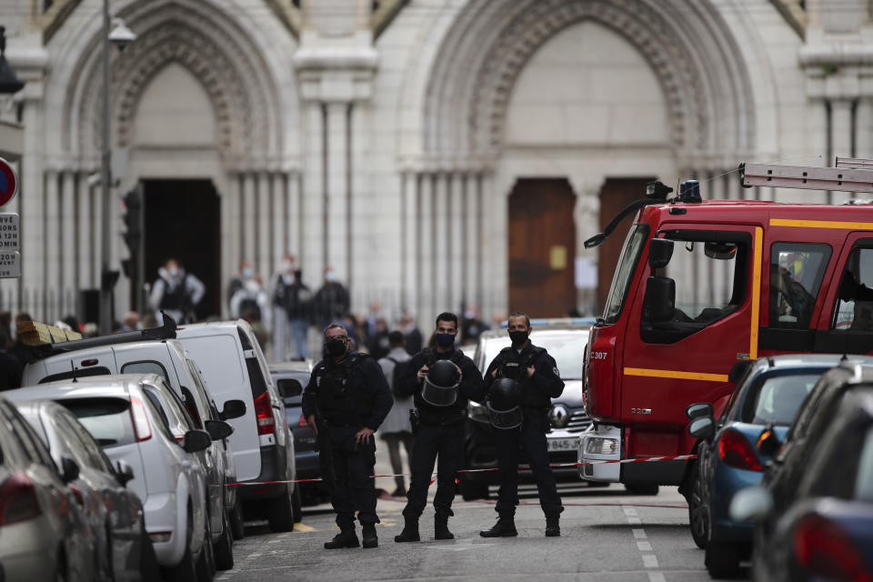 Police officers stand guard near Notre Dame church in Nice, southern France, Thursday, Oct. 29, 2020. An attacker armed with a knife killed at least three people at a church in the Mediterranean city of Nice, prompting the prime minister to announce that France was raising its security alert status to the highest level. It was the third attack in two months in France amid a growing furor in the Muslim world over caricatures of the Prophet Muhammad that were re-published by the satirical newspaper Charlie Hebdo. (AP Photo/Daniel Cole)