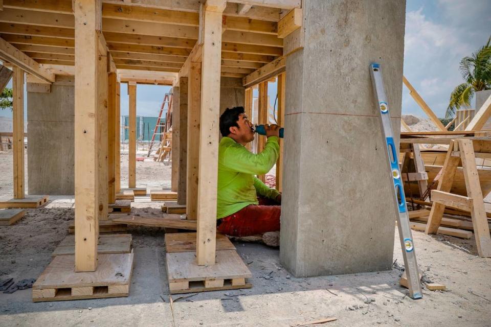 Laborer Antonio Bonilla shelters from the sun during a water break at a residential construction site on Key Biscayne, Florida on Friday, May 17, 2024.