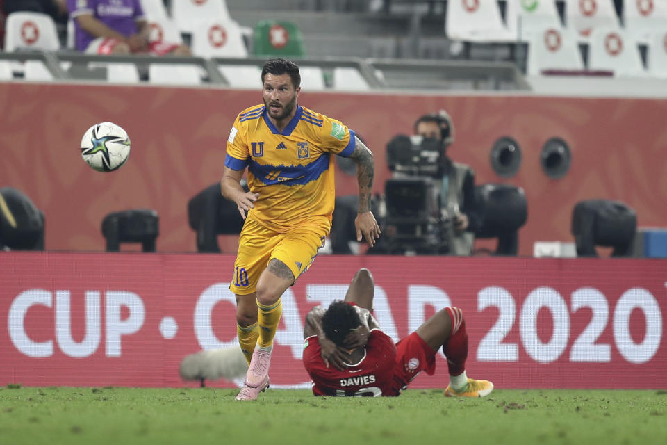 Alphonso Davies (en el piso) del Bayern Múnich en la pugna de un balón con André-Pierre Gignac de Tigres de México en la final del Mundial de Clubes, en Al Rayyan, Catar, el jueves 11 de febrero de 2021. (AP Foto)