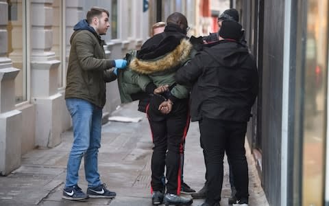 A suspect being detained during the facial recognition trial  - Credit: London News Pictures