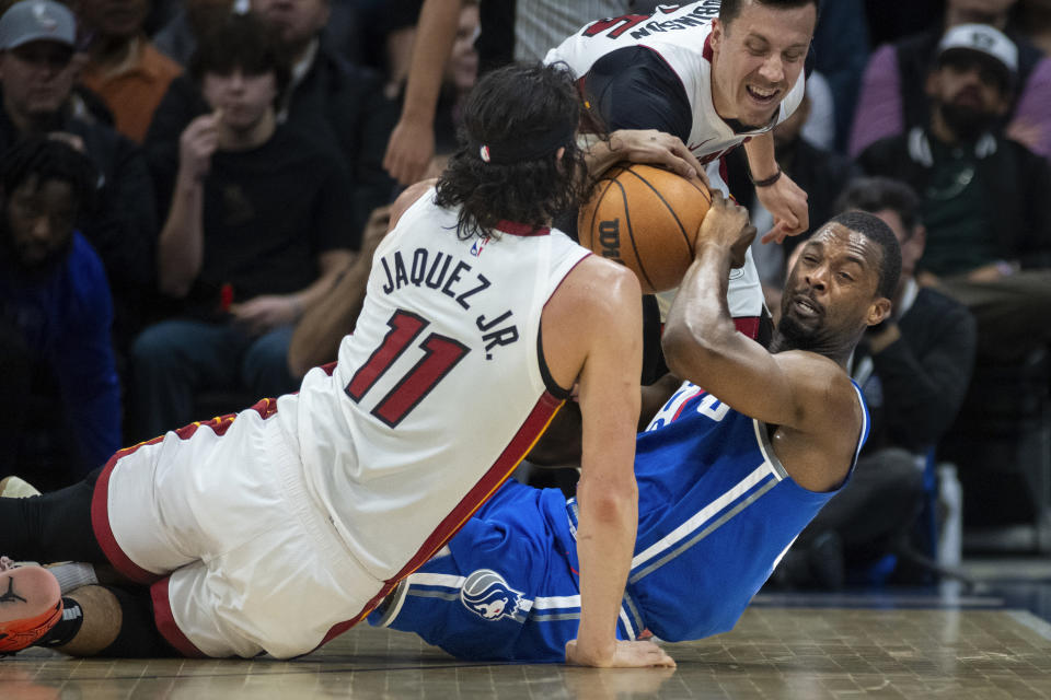 Sacramento Kings forward Harrison Barnes, bottom right, tries to pass the ball while Miami Heat guard Jaime Jaquez Jr. (11) and forward Duncan Robinson, top right, defend in the first quarter of an NBA basketball game in Sacramento, Calif., Monday, Feb. 26, 2024. (AP Photo/José Luis Villegas)