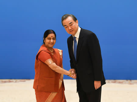 Indian Foreign Minister Sushma Swaraj (L) shakes hands with Chinese State Councilor and Foreign Minister Wang Yi before a meeting of foreign ministers and officials of the Shanghai Cooperation Organisation (SCO) at the Diaoyutai State Guest House in Beijing, China, April 24, 2018. Madoka Ikegami/Pool via REUTERS