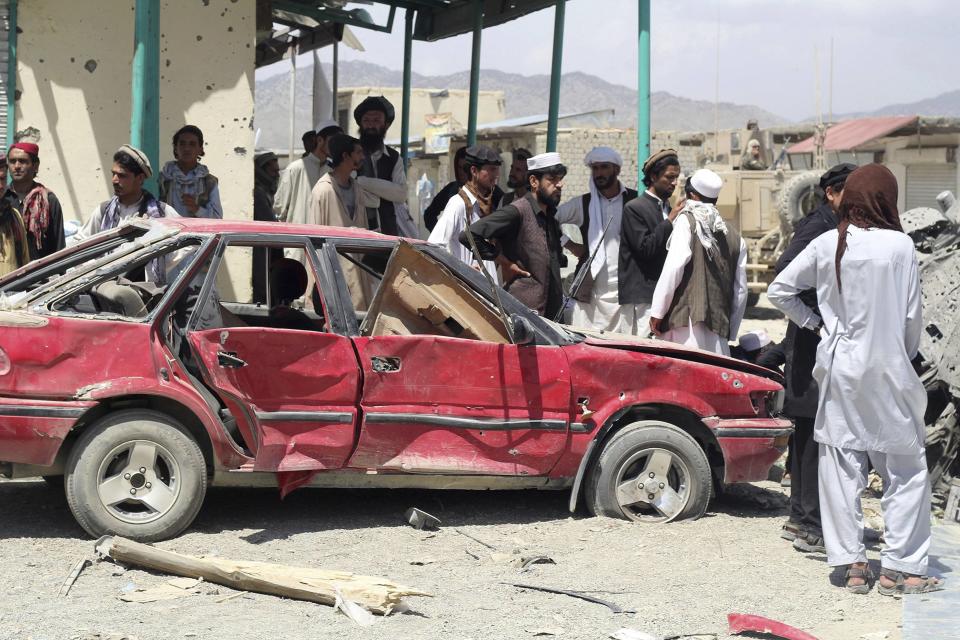 Villagers gather at the site of a car bomb attack in Urgon district, eastern province of Paktika July 15, 2014. A car packed with explosives exploded on Tuesday as it sped through a crowded market in Paktika, killing at least 89 people, officials said, one of the most violent attacks in the country in a year. (REUTERS/Stringer)