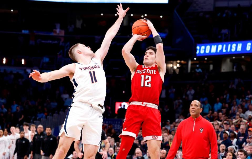 N.C. State’s Michael O’Connell (12) makes a three-pointer as time expires to tie the game in regulation during the Wolfpack’s 72-65 overtime victory over Virginia in the semifinals of the 2024 ACC Men’s Basketball Tournament at Capital One Arena in Washington, D.C., Friday, March 15, 2024. Virginia’s Isaac McKneely (11) defends.