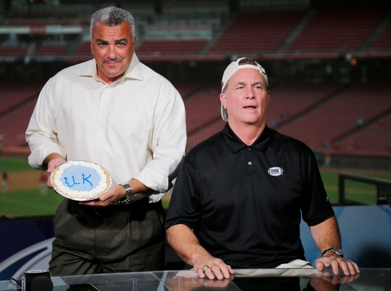 Broadcaster Jeff Piecoro shows off a University of Kentucky themed pie before smashing it in the face of Jeff Brantley to settle a college football bet between the two before the MLB Interleague game between the Cincinnati Reds and the Kansas City Royals at Great American Ball Park in downtown Cincinnati on Tuesday, Sept. 25, 2018.