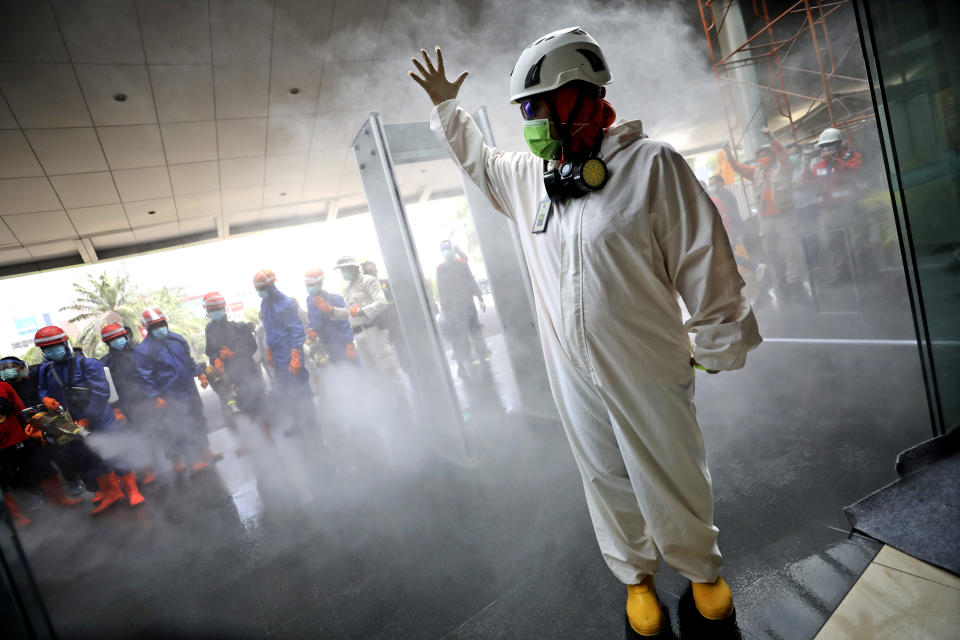 A team leader makes a hand signal as Indonesian firemen test their equipment prior to disinfecting Margo City shopping mall to help curb the spread of the new coronavirus outbreak, after a number of employees of a supermarket at the mall were tested positive for the virus, in Depok, Indonesia, Saturday, Aug. 22, 2020. (AP Photo/Dita Alangkara)