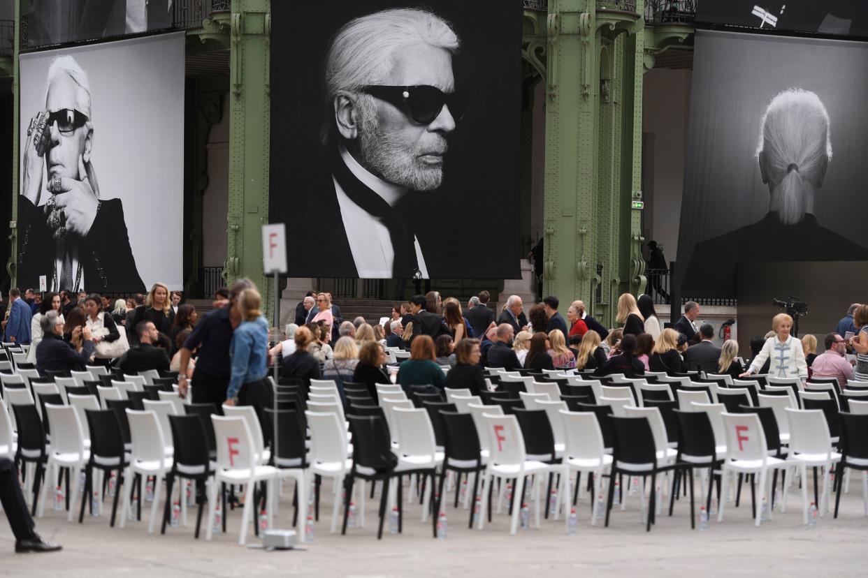 People arrive at the Grand Palais, decorated with photographs picturing late German fashion designer Karl Lagerfeld, at the start of the "Karl For Ever" event to honour him in Paris, on June 20, 2019. - The late designer for the French label Chanel, Karl Lagerfeld, died at the age of 85, on February 19, 2019, in Paris. (Photo by CHRISTOPHE ARCHAMBAULT / AFP)        (Photo credit should read CHRISTOPHE ARCHAMBAULT/AFP via Getty Images)