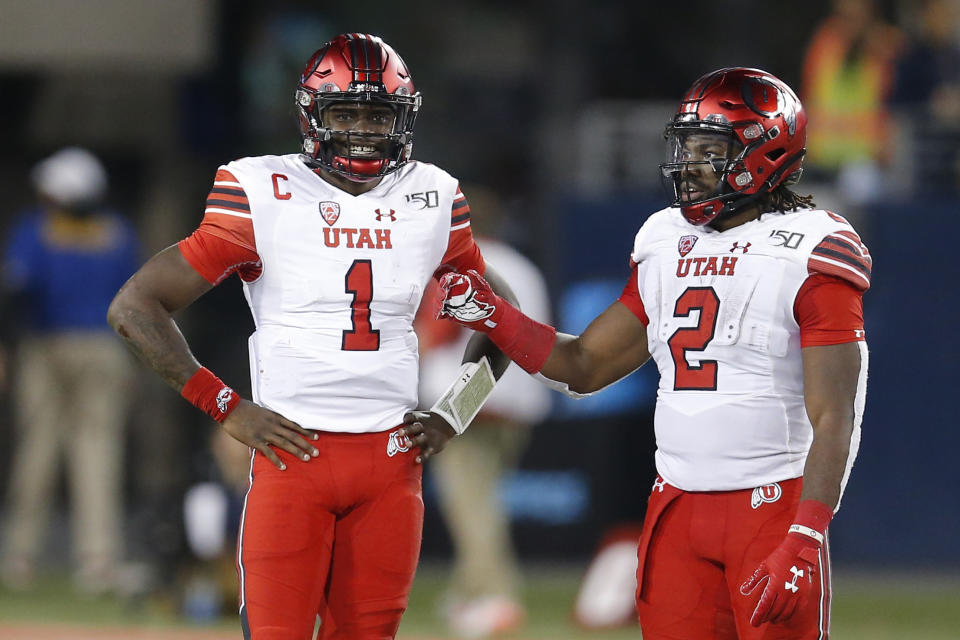 Utah quarterback Tyler Huntley (1) and Zack Moss (2) in the first half during an NCAA college football game against Arizona, Saturday, Nov. 23, 2019, in Tucson, Ariz. (AP Photo/Rick Scuteri)