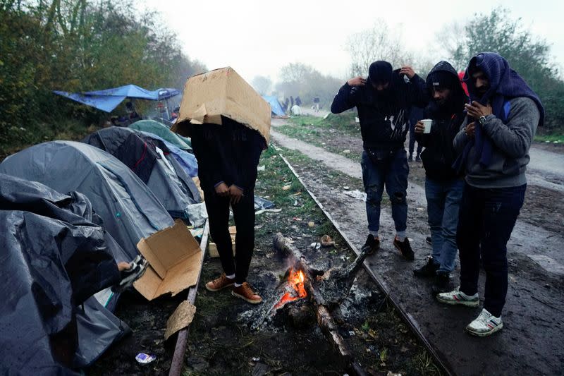 Wider Image: En un campo de inmigrantes en Francia, un hombre vende sándwiches para pagarle a los traficantes