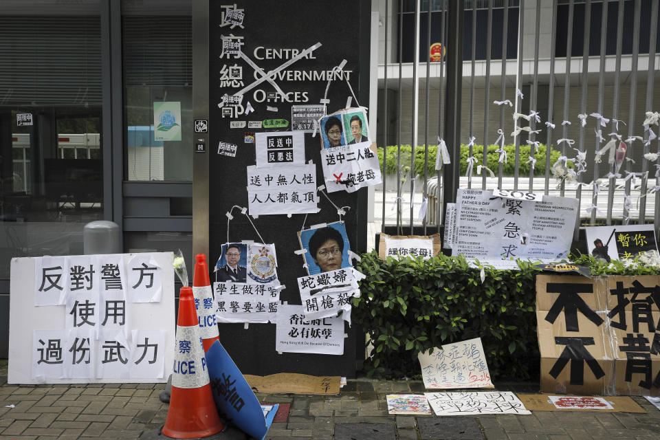 FILE - In this Tuesday, June 18, 2019, file photo, posters and placards bearing photos of Hong Kong Chief Executive Carrie Lam and police commissioner Stephen Lo Wai-chung which left by protesters are placed outside the Legislative Council in Hong Kong. Many analysts expect Lam will eventually step down to take responsibility for the mess resulting from her effort to fast-track the extradition bill, which would allow some suspects in Hong Kong to be tried in mainland Chinese courts. On Tuesday, June 18, 2019, she apologized and said she needed to do better, but also insisted she wants to finish her 5-year term. (AP Photo/Vincent Yu, File)