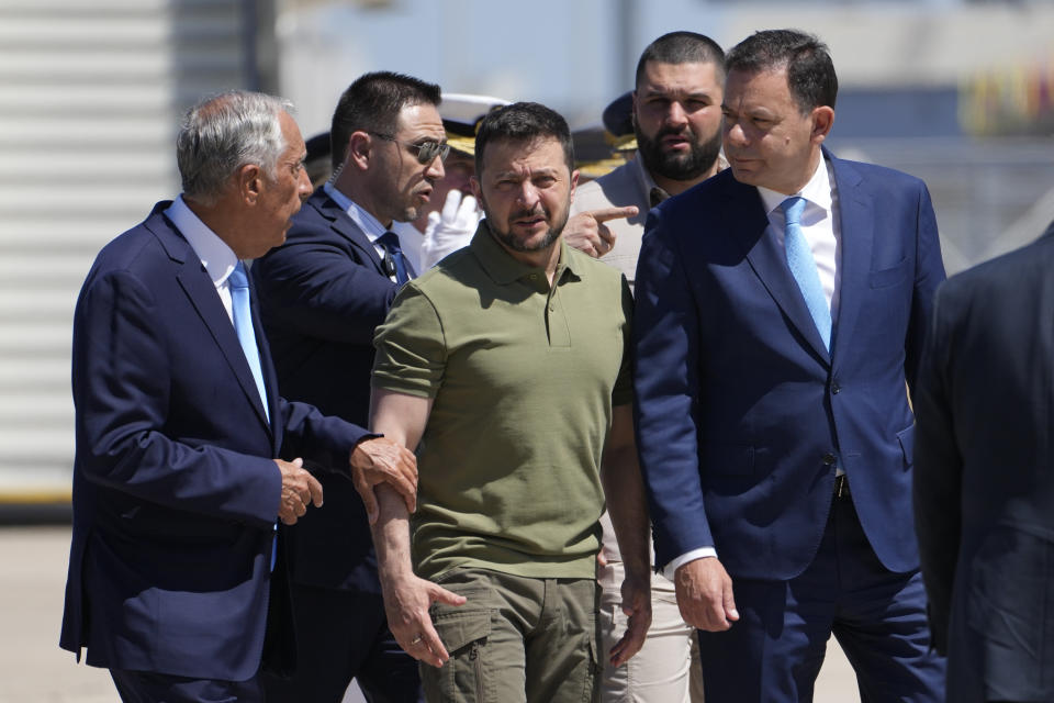 Ukrainian President Volodymyr Zelenskyy, center is welcomed by Portuguese President Marcelo Rebelo de Sousa, left and Portuguese Prime Minister Luis Montenegro at the military airport in Lisbon, Tuesday, May 28, 2024. (AP Photo/Armando Franca)