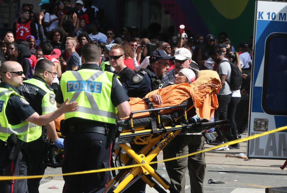 A woman with a head injury is stretchered into an ambulance. Source: Getty