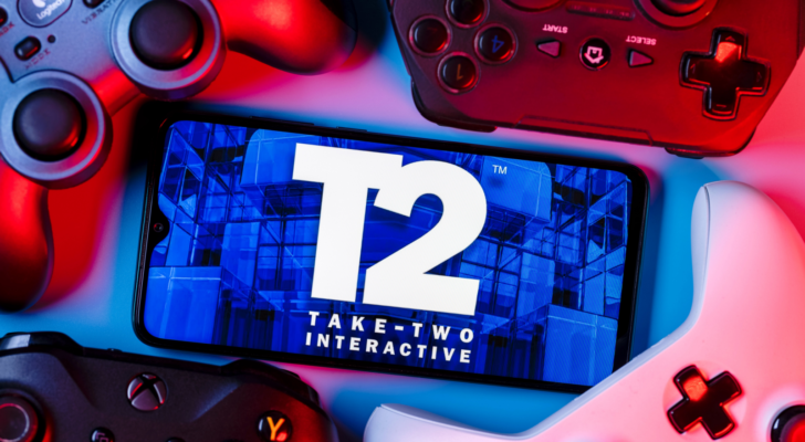 Take-Two Interactive Software, Inc. (TTWO) is an American video game holding company. A smartphone with the Take-Two logo on the screen surrounded by gamepads.