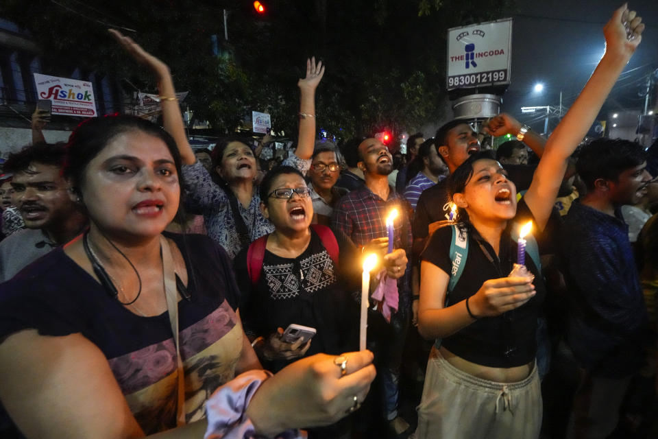 Students join other protesters in a midnight rally protesting against the murder of a 31 year old post-graduate trainee demanding proper investigation in Kolkata, India, Wednesday, Aug. 14, 2024. (AP Photo/Bikas Das)