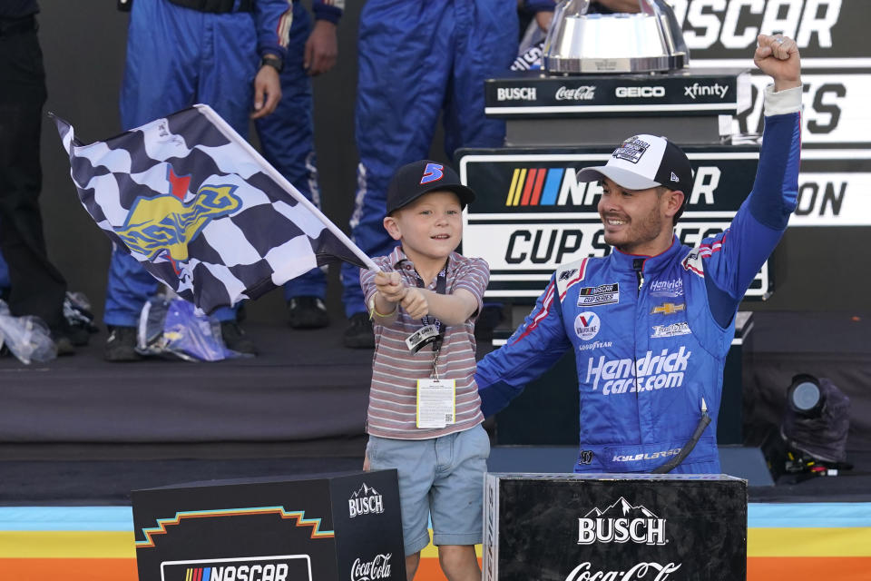 Kyle Larson, right, and his son Owen celebrate after winning a NASCAR Cup Series auto race and championship on Sunday, Nov. 7, 2021, in Avondale, Ariz. (AP Photo/Rick Scuteri)