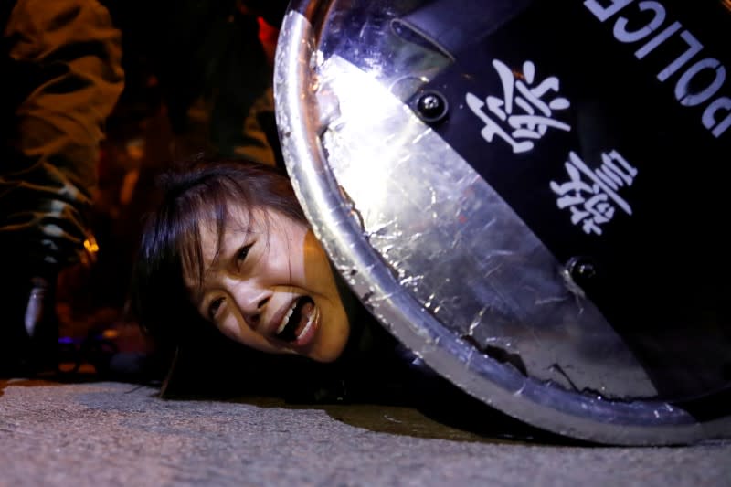FILE PHOTO: An anti-extradition bill protester is detained by riot police during a protest outside Mong Kok police station in Hong Kong