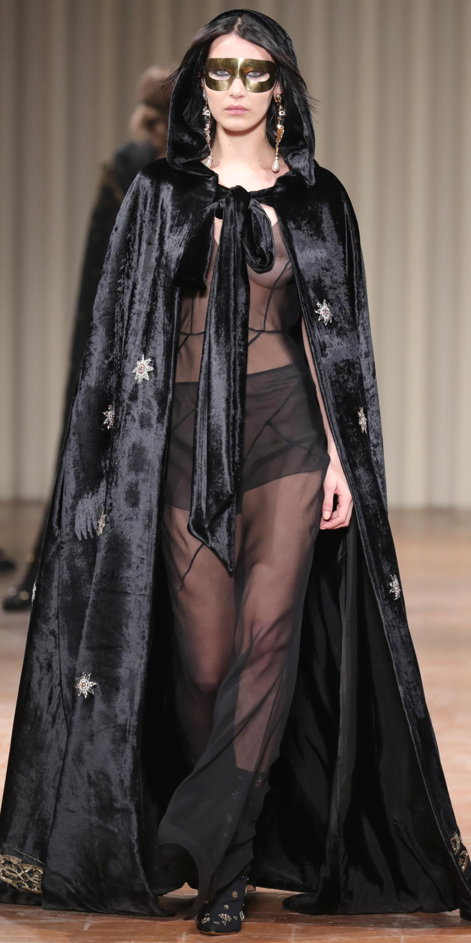 <p>The masked crusader made her way down Alberta Ferretti's runway at Milan Fashion Week in a totally sheer dress and velvet floor-length cape. </p>