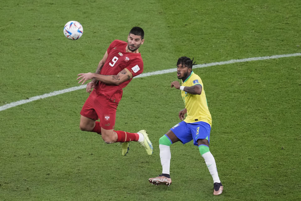 Serbia's Aleksandar Mitrovic, left, heads the ball infant of Brazil's Fred during the World Cup group G soccer match between Brazil and Serbia, at the the Lusail Stadium in Lusail, Qatar on Thursday, Nov. 24, 2022. (AP Photo/Darko Vojinovic)