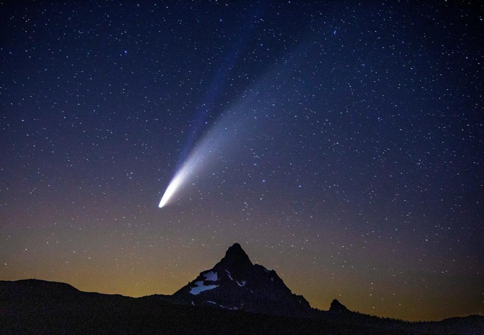 Comet Neowise appears over Mount Washington in the night sky as seen from Dee Wright Observatory on McKenzie Pass east of Springfield, Ore., Tuesday, July 14, 2020.