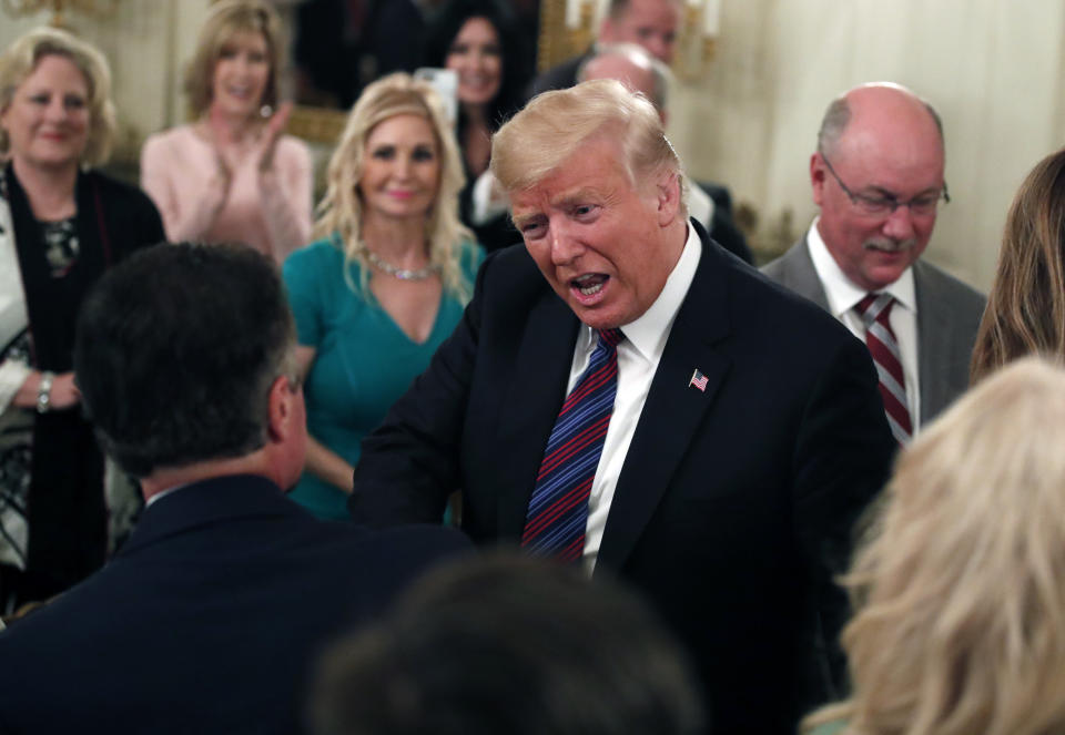 President Donald Trump, center, greets people as he arrives to speak during a dinner for evangelical leaders in the State Dining Room of the White House, Monday, Aug. 27, 2018, in Washington. (AP Photo/Alex Brandon)