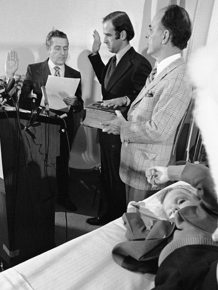 Four-year-old Beau Biden plays as his father, centre, is sworn in as the US senator for Delaware in a Wilmington hospital in January 1973