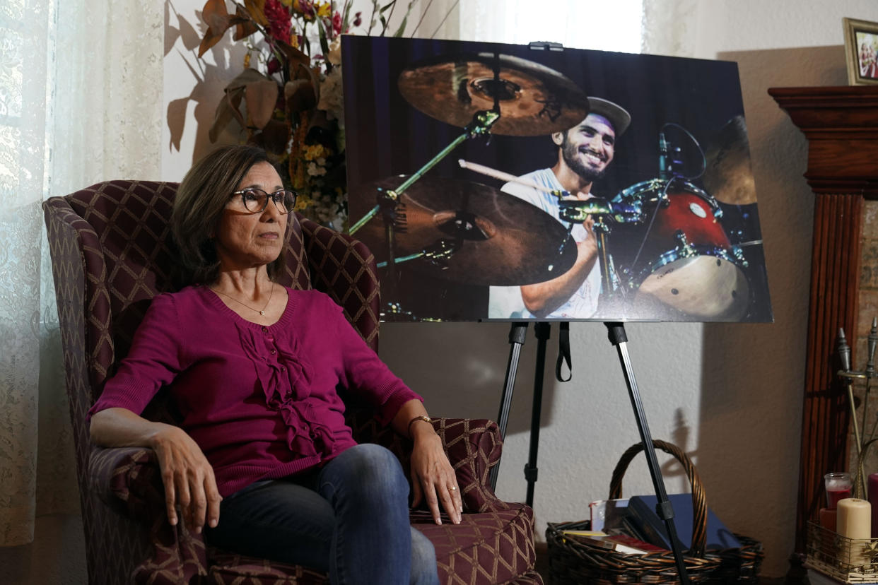 Dolores Cruz poses next to a photo of her son, Eric Cruz, on Wednesday, Feb. 1, 2023, at her home in San Gabriel, Calif. Cruz published an essay in 2022 about grieving for her son, who died in a car crash in 2017. "Died Suddenly" used a screenshot of the headline in the film, portraying his death as vaccine related. (AP Photo/Marcio Jose Sanchez)