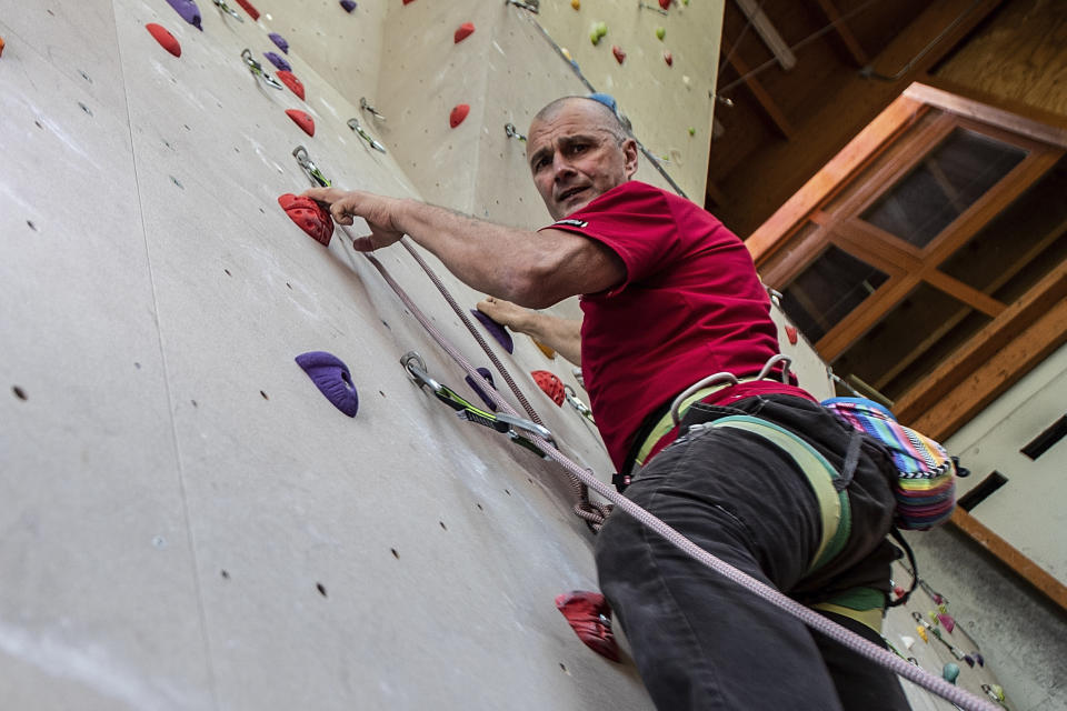 In this image take on Thursday, April 23, 2020 Giorgio Masserini, 61, poses inside the climbing gym 'Parco della Montagna', in Castione della Presolana, near Bergamo, northern Italy. His attitude is "Life is made of challenges". (AP Photo/Luca Bruno)