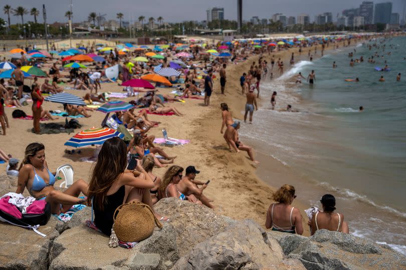 People cool off in the water during warm weather on a beach in Barcelona, Spain, Sunday, June 19, 2022.