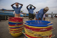 Laborers wearing masks as a precaution against COVID-19 get ready to collect fish from a fishing boat on the Arabian Sea coast in Kochi, Kerala state, India, Monday, Sept.20, 2021. The tiny southern state continues to battle the highest number of coronavirus cases in the country. (AP Photo/R S Iyer)