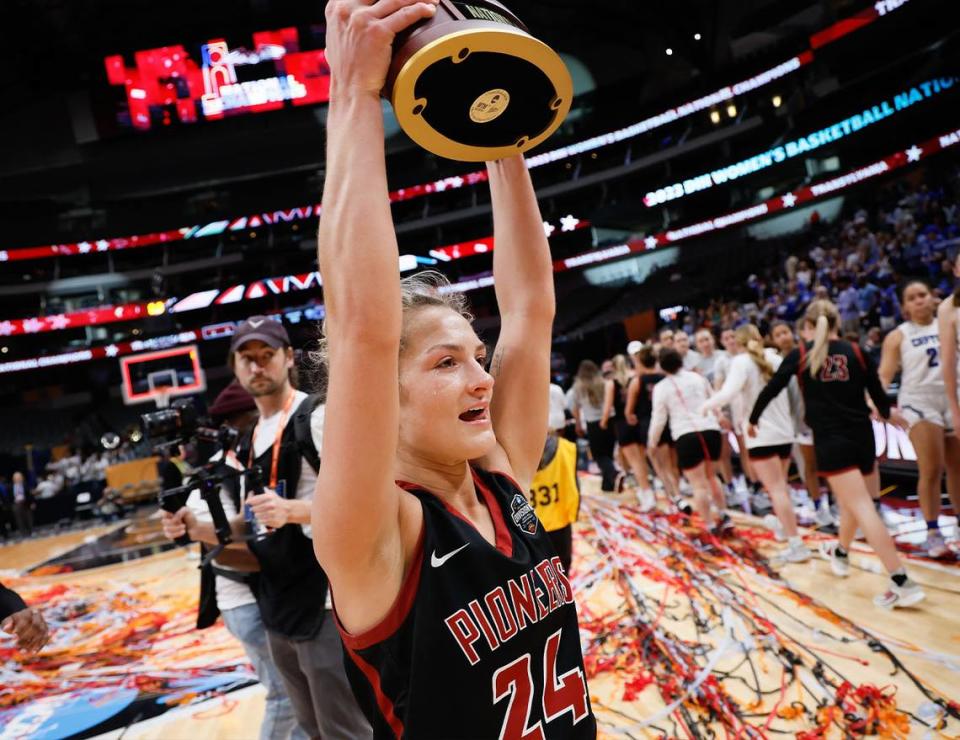 Transylvania senior guard Kennedi Stacy holds the national championship trophy following the NCAA Division III Tournament title game Saturday. Stacy had eight steals for the Pioneers.